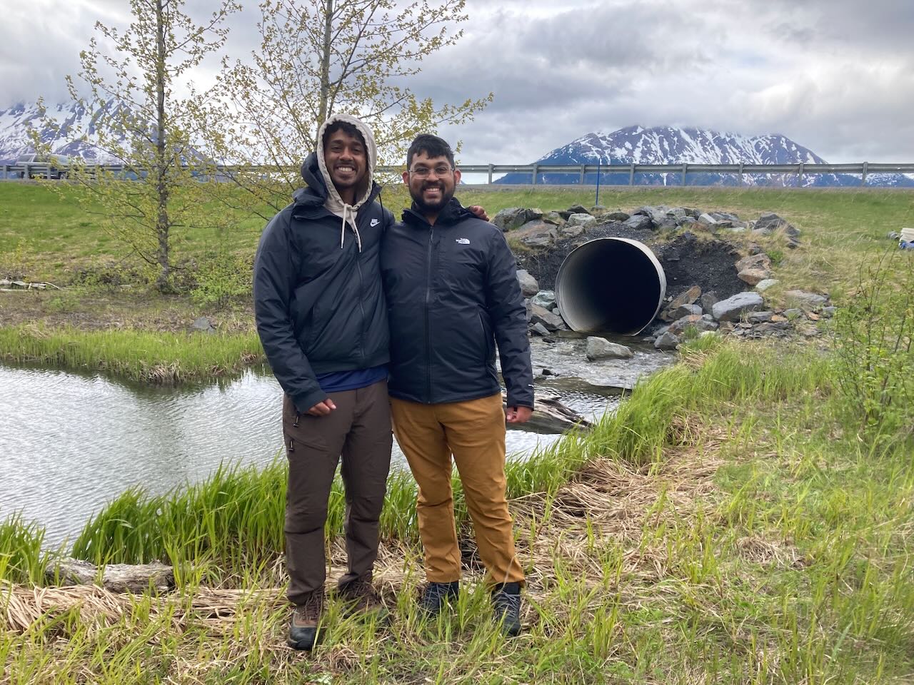 Students posing near a culvert connecting one of our study lakes to Cook Inlet